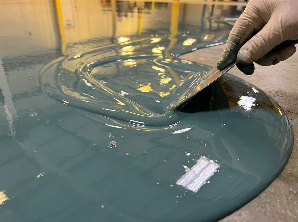 Resin floor coating being applied by hand